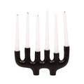 Black candle holder with six white candles on a white background