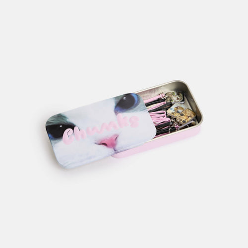 Tin box with a cat design and hair clips on a white background