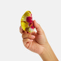 Hand holding a colorful butterfly-shaped object against a white background