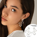 Woman wearing a pair of silver earrings with an inset showing earring details and weight information.