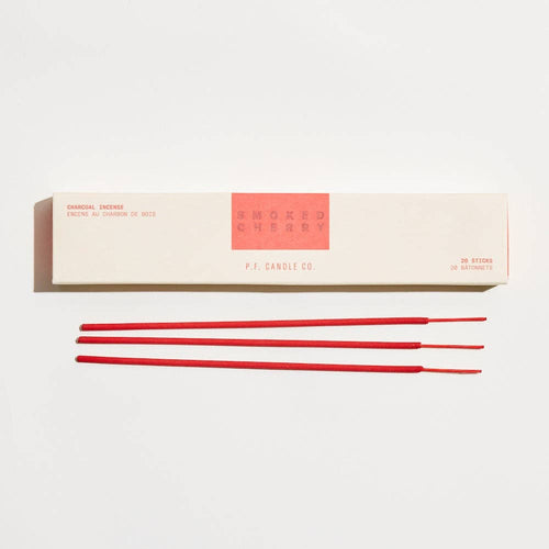 Red incense sticks in front of a white box with 'Mokko' branding on a light gray background