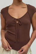 Brown top with a tie detail worn by a person on a plain background