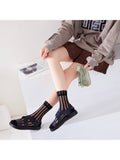 Person wearing black mesh socks with sandals on a white background