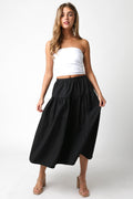 Woman wearing a white top and black skirt on a white background