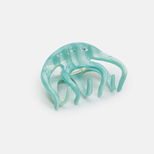 Turquoise hair clip on a light gray background