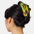 Person with a green and brown butterfly hair clip in their hair on a white background