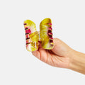 Hand holding a colorful butterfly-shaped object against a white background