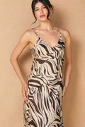 close up of model wearing brown and white zebra dress on tan background