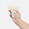 Hand holding a white, textured object against a white background