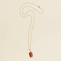 amber and gold charm necklace on white background
