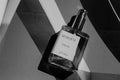 Perfume bottle labeled 'Geneve' on a geometric background