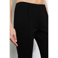 Black pants worn by a person on a white background