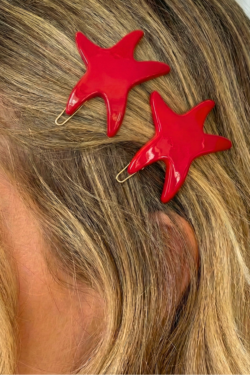 Two glossy red starfish hair clips holding back blonde hair, shown on a model's head with a French-Amie watermark in the top right.