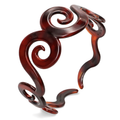 Decorative tortoiseshell stand with intricate spiral design on a white background