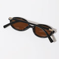 Black sunglasses with gold accents on a white background