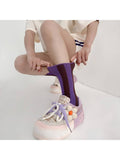 A person crouching while pulling up a purple ribbed crew sock, wearing a light pink and white platform sneaker with a flower embellishment.