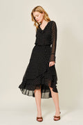 Woman wearing a black polka dot dress on a white background