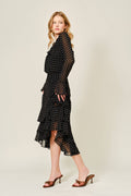 Woman wearing a black polka dot dress on a beige background