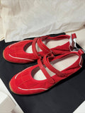 Red shoes with white soles on a black surface