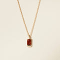 amber and gold charm necklace on white background