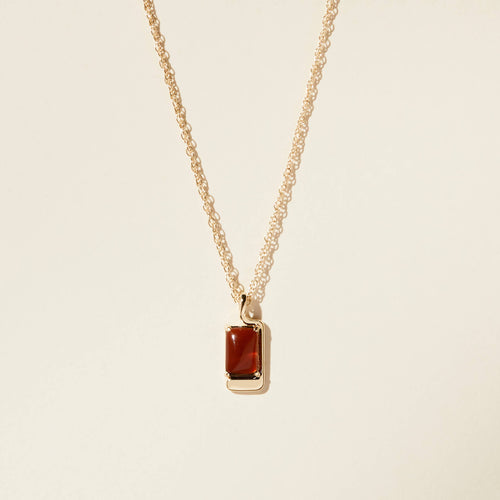 amber and gold charm necklace on white background