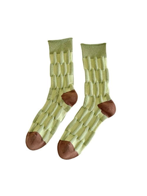 Pair of green socks with brown toes and heels on a white background