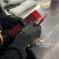Person wearing black gloves holding red sticks on a metallic surface with text 'Made in Los Angeles by our team.'