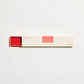 Box of incense sticks with red and pink design on a white background