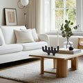 Modern living room with a white sofa, wooden coffee table, and decorative items.