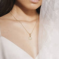 woman wearing Gold ring and charm necklace