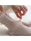 Close-up of a person wearing pink patterned socks with lace details.