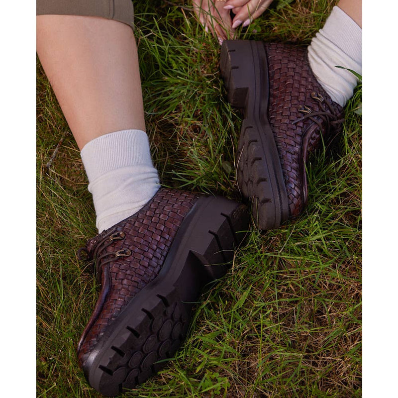 Brown woven shoes on grass with white socks
