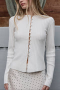Woman wearing a white ribbed cardigan with buttons outdoors