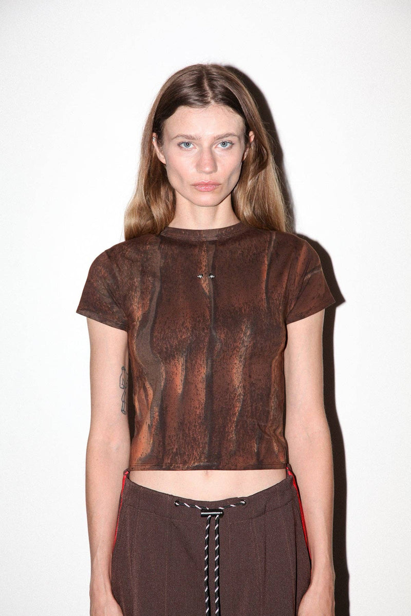 Model wearing a brown textured top and pants on a white background