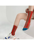 A person seated with both legs visible, wearing a pair of knee-high athletic socks. The socks are bright red with tan vertical stripes and a blue toe cap.