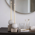 Decorative setup with candles, glasses, and small objects on a surface.