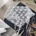 White lace handkerchief on a black surface with a blurred background