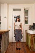 Woman standing in a kitchen with wooden floor and white walls