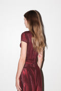 Woman wearing a red dress with a plain white background