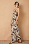 model wearing brown and white zebra dress on tan background