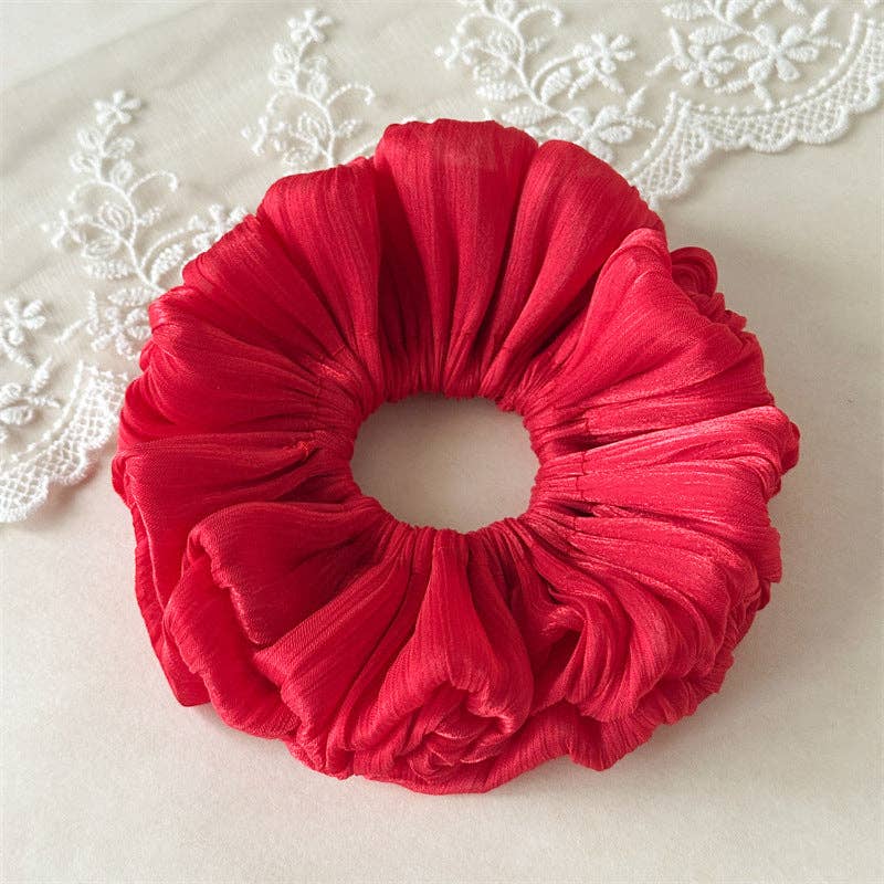 Red scrunchie on a light background with lace details