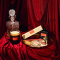 Decorative items including a candle, bottle, and boxes on a red fabric background