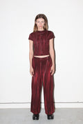 Person wearing a maroon outfit with a white background