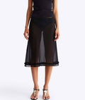 Black sheer skirt worn by a person on a white background