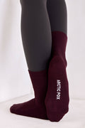 Maroon socks with 'Arctic Fox' branding worn by a person on a white background
