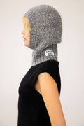 Person wearing a gray knitted hood with 'Arctic Fox' branding on a white background