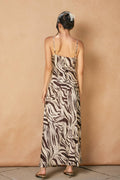 back of model wearing brown and white zebra dress on tan background
