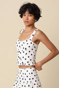 Woman wearing a polka dot outfit against a beige background
