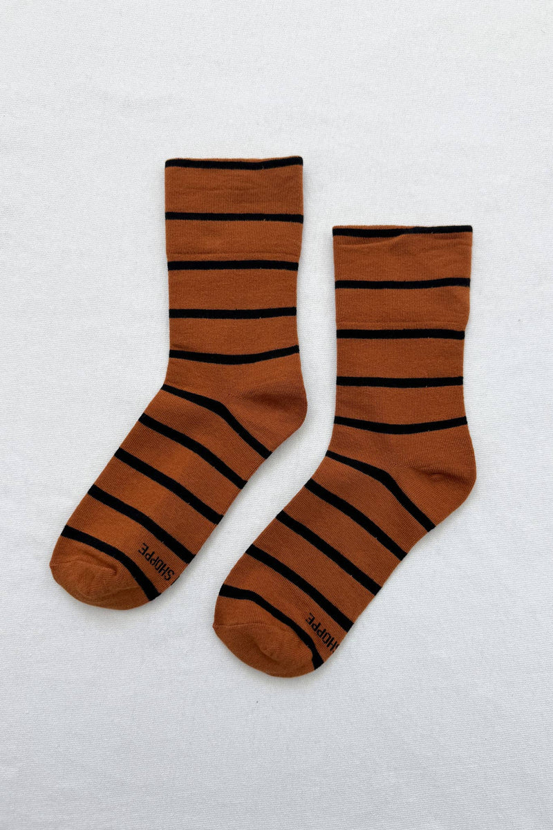 Pair of brown socks with black stripes on a white background