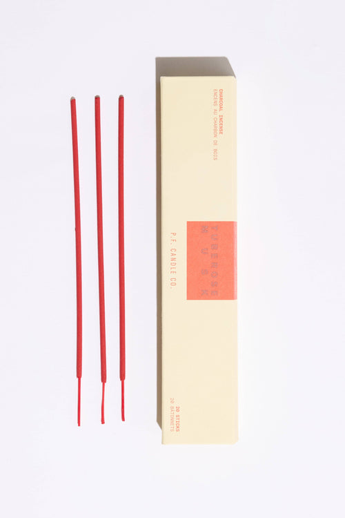 Red incense sticks with a beige box on a white background
